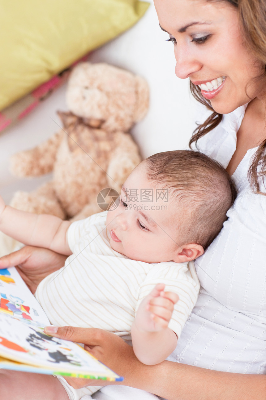喜悦的母亲的肖像 为她坐在这的婴儿念书图片