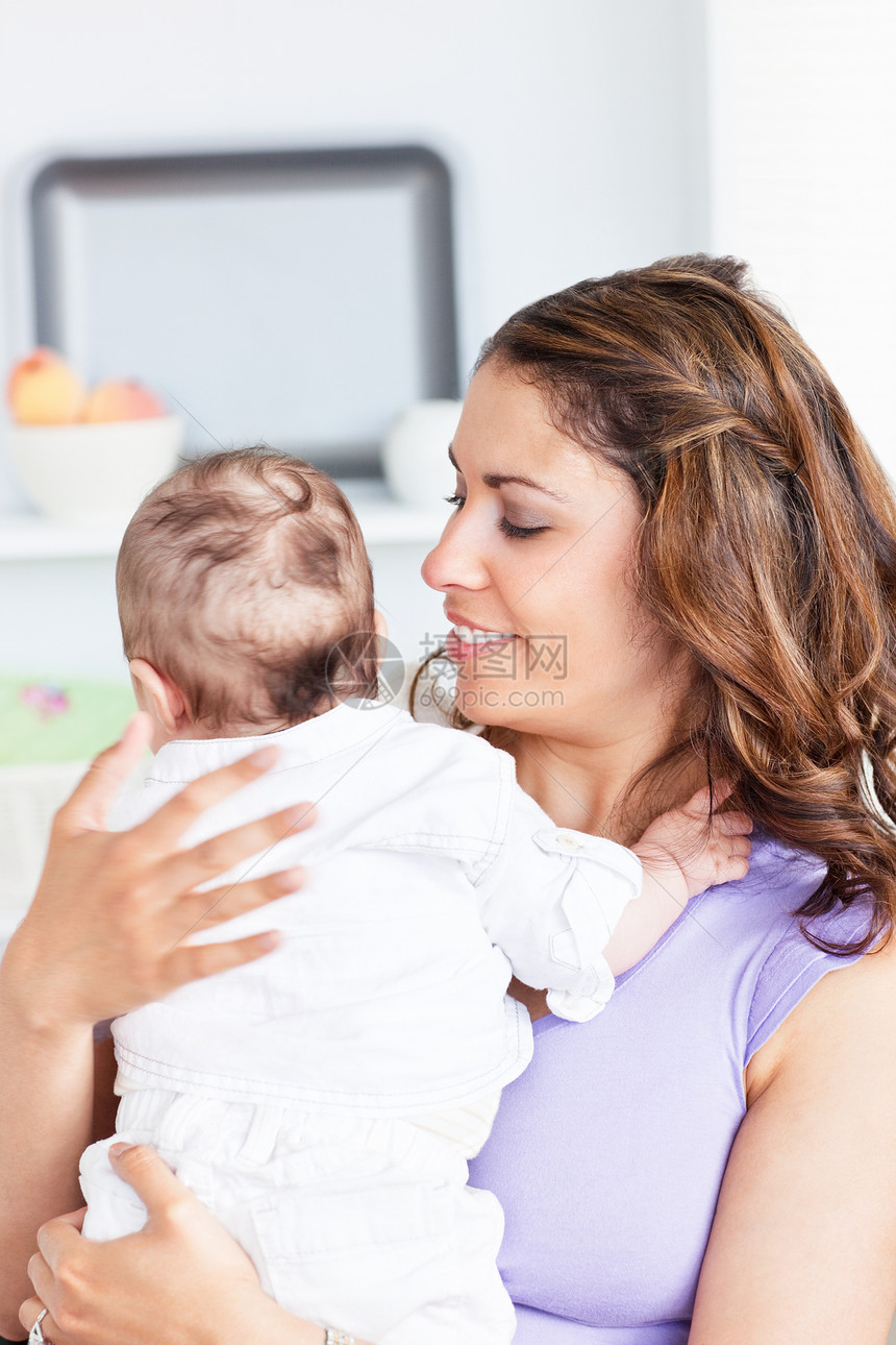 一位抱着新生儿的幸福母亲的肖像 她站在图片