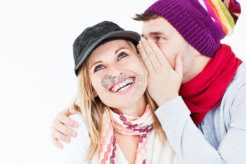 戴帽子的帅哥向笑笑的女孩朋友透露一个秘密图片