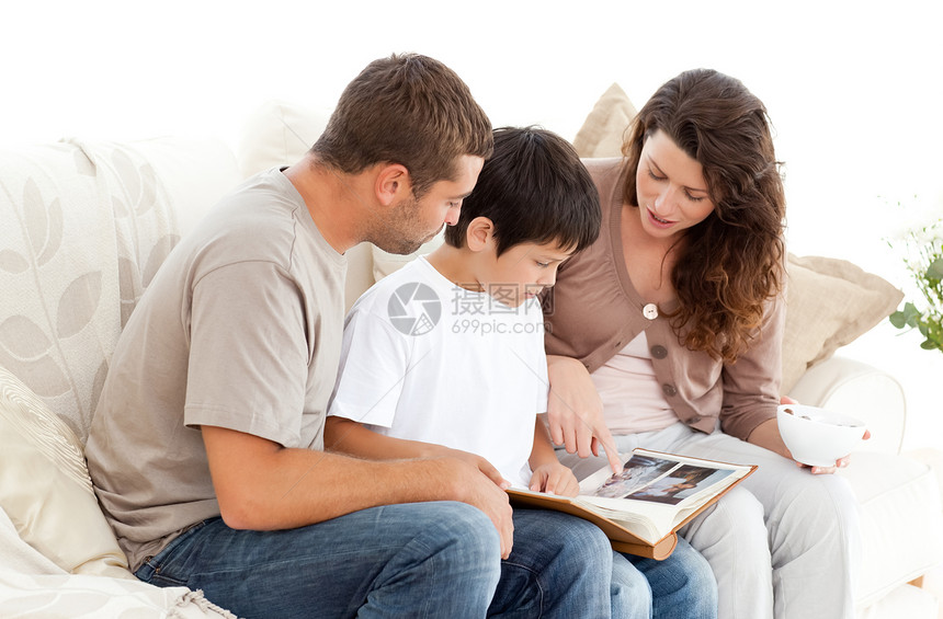 幸福的一家人一起看沙发上的照片专辑图片