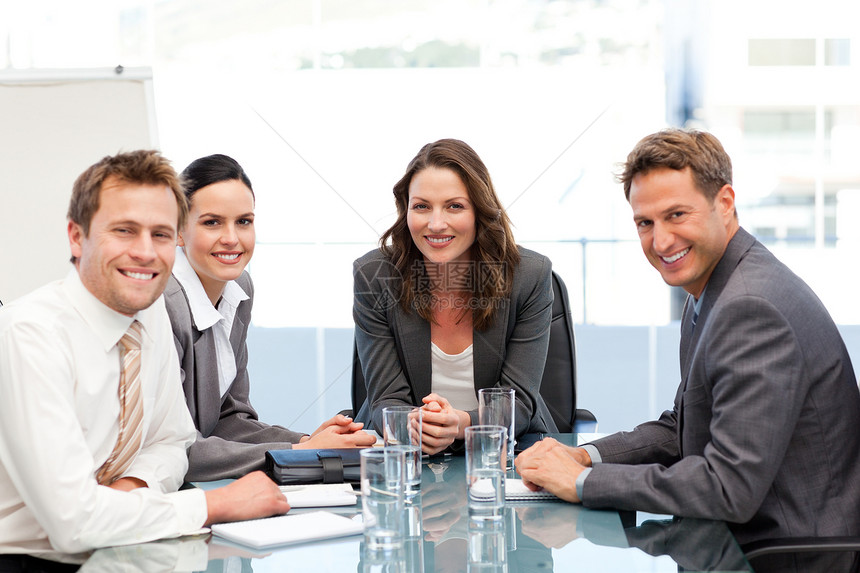 一名女商务人士的肖像 她的团队坐在一张桌子上图片