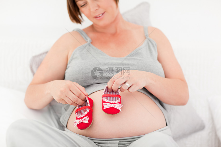 带孩子鞋的孕妇母亲婴儿母性妈妈父母长椅靴子成人白色沙发图片