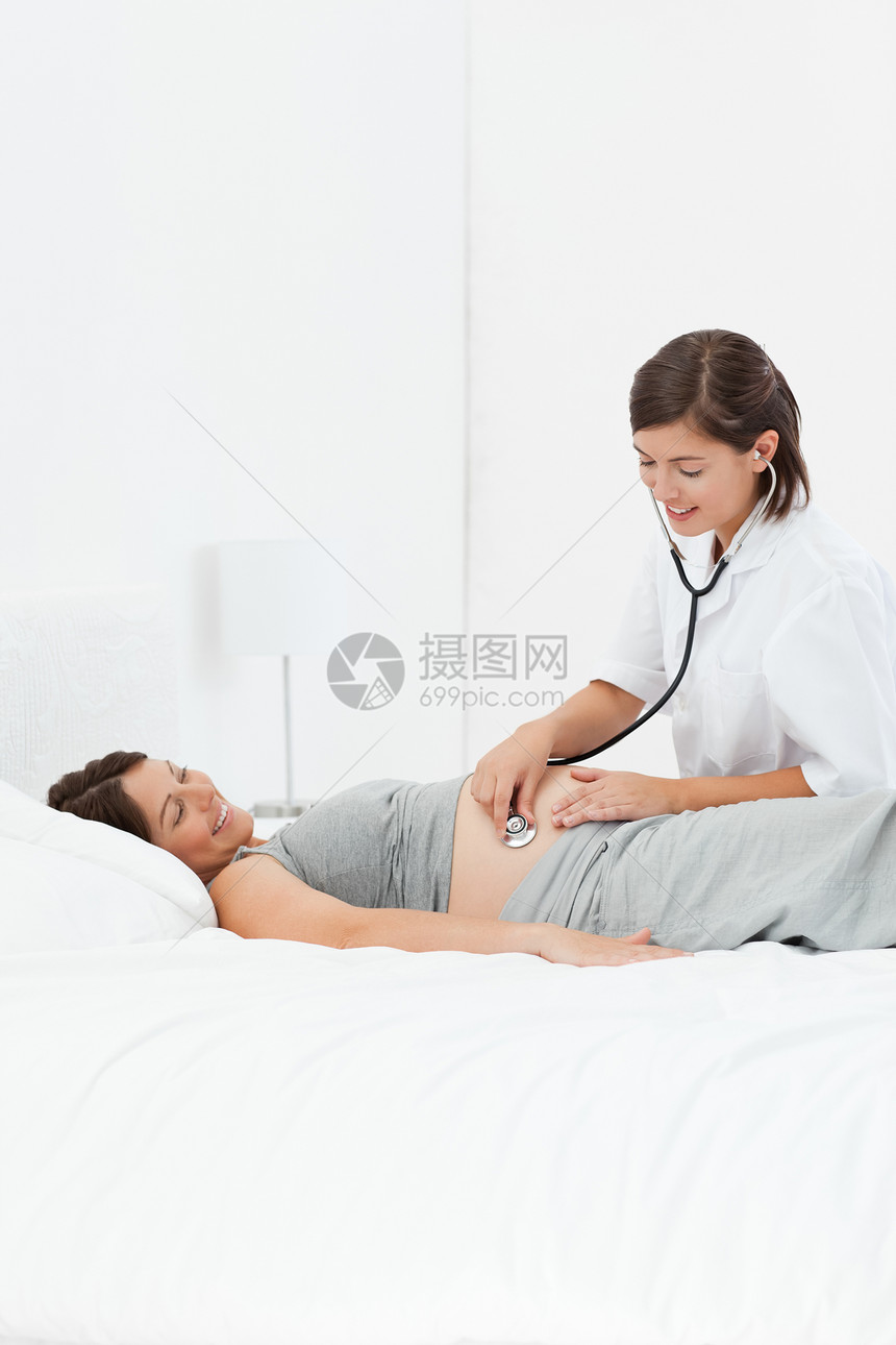 带护士的孕妇享受喜悦女士情感幸福白色怀孕父母腹部婴儿图片