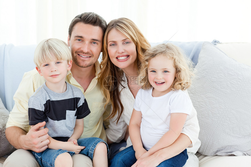 在他们的沙发上可爱的家庭相机孩子们父亲女性爸爸男性感情幸福拥抱房间图片