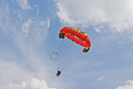 远动服女滑翔机从云中坠落背景