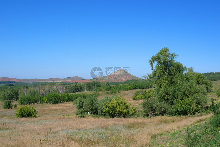 美丽的有山的夏月风景牧场顶峰场景城市蓝色天空绿色土地草地地形图片