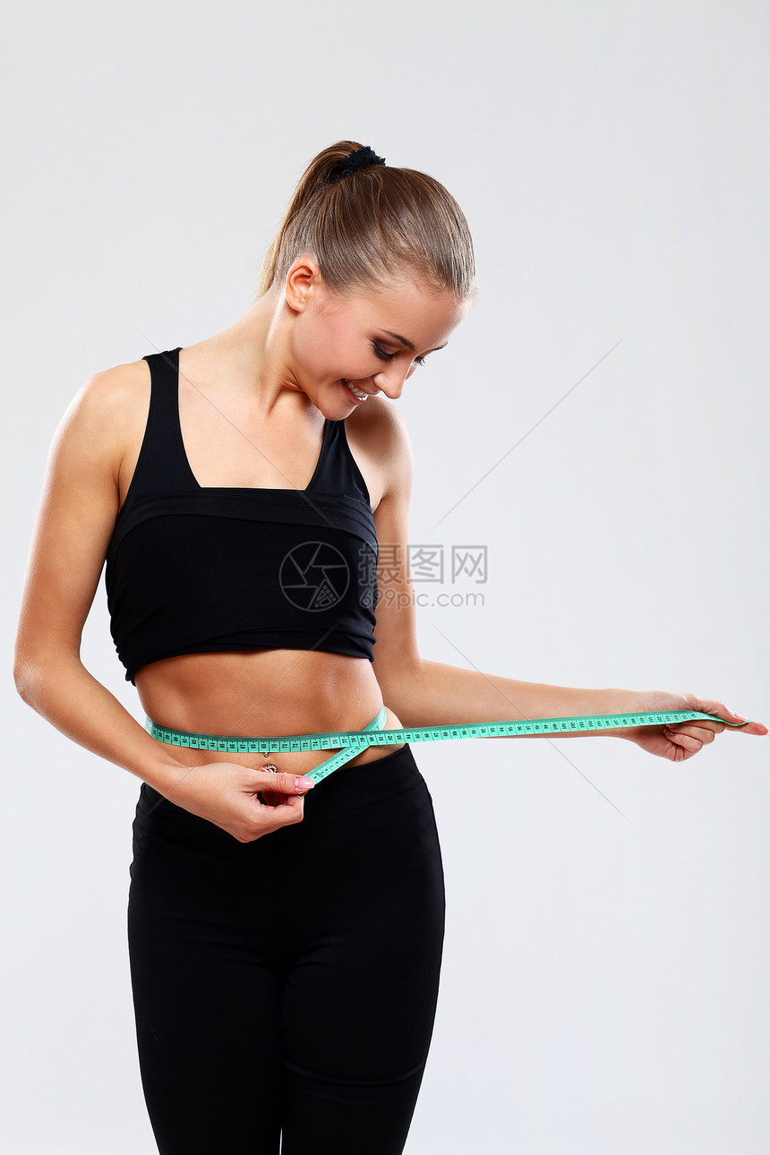 快乐的女孩用尺子测量腰部青年磁带统治者身体温泉棕褐色减肥橘皮数字女性图片