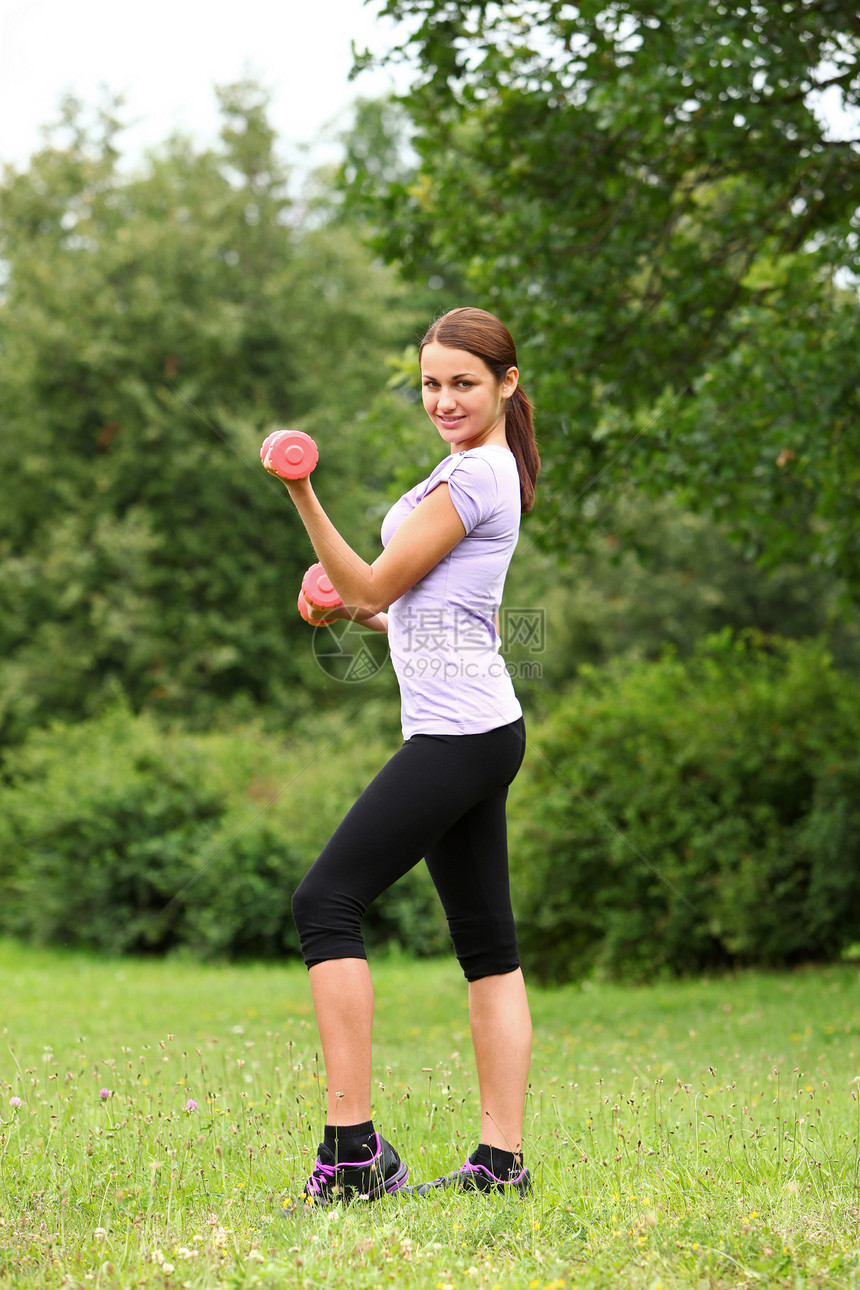 女人在公园里用哑铃做运动活动福利幸福娱乐女孩女性瑜伽成人训练重量图片