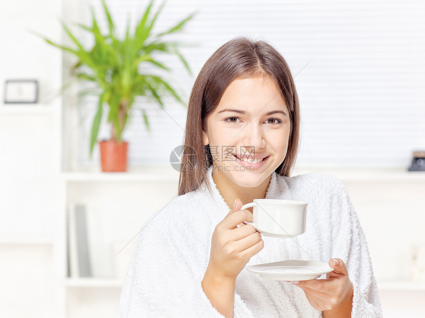 穿浴袍的女人在家放松微笑浴衣杯子女孩休息房间女性咖啡植物黑发图片