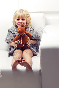 沙发上有熊的小女孩动物毯子就寝健康青年女儿童年喜悦微笑拥抱美丽的高清图片素材