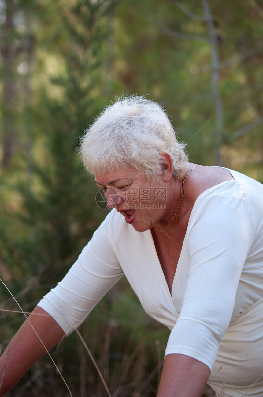 年长的女士在外面公园里锻炼树叶祖父母衣服损失季节叶子退休享受老年祖母图片
