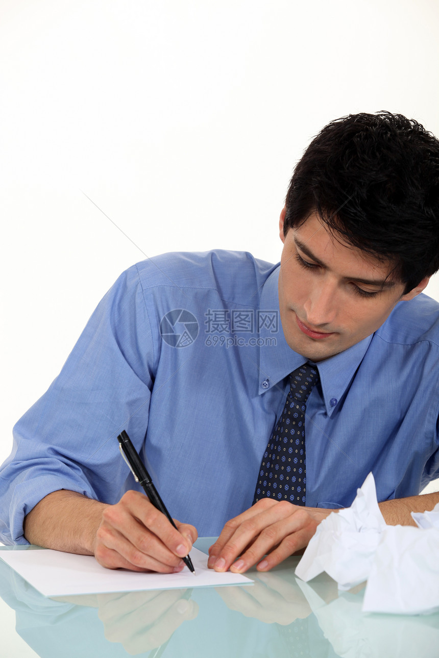 在书桌上写作的沮丧男子图片