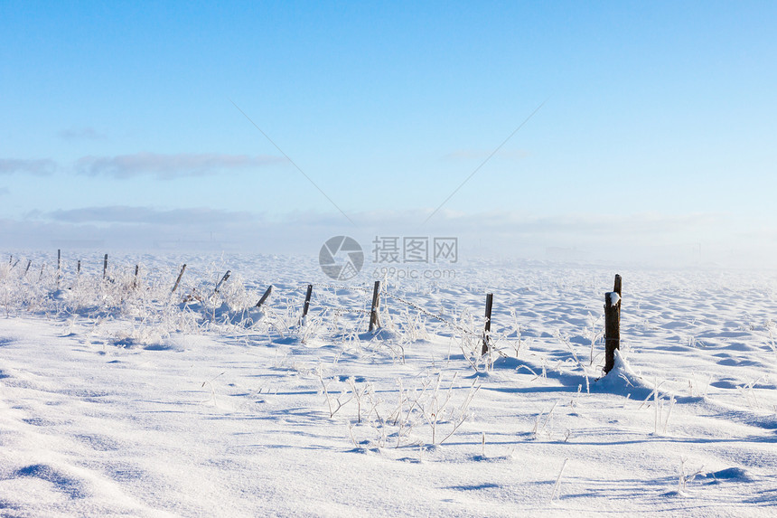 带雪覆盖地面的刺铁丝栅栏乡村牧场蓝色倒钩照片金属草地天气薄雾农场图片