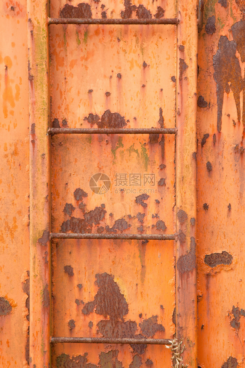 垂直图像上的旧橙色和生锈容器的台阶图片