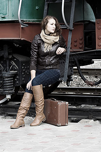 女孩在旧列车的平台上等待着落地高清图片