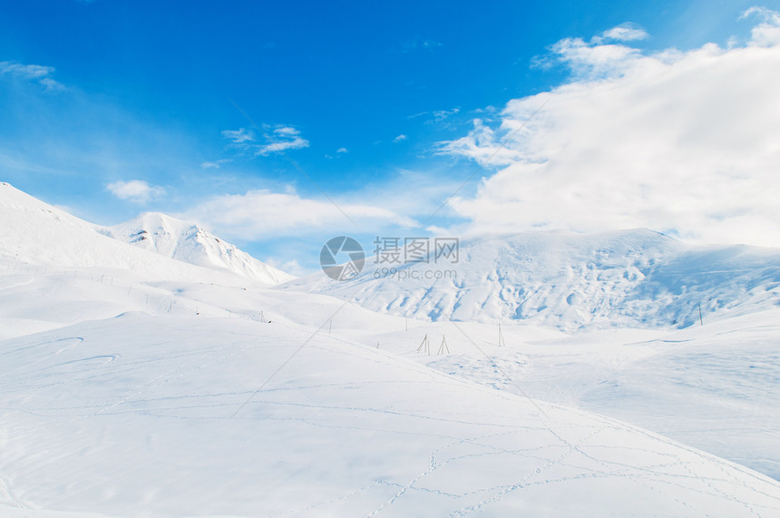 明亮的冬天天雪山蓝色白色山脉冰川阳光天空旅行岩石场景滑雪图片