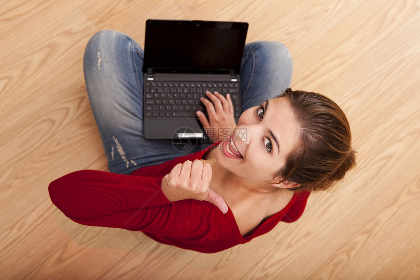 使用笔记本电脑工作的妇女地面技术享受黑发互联网女孩快乐学习红色女性图片