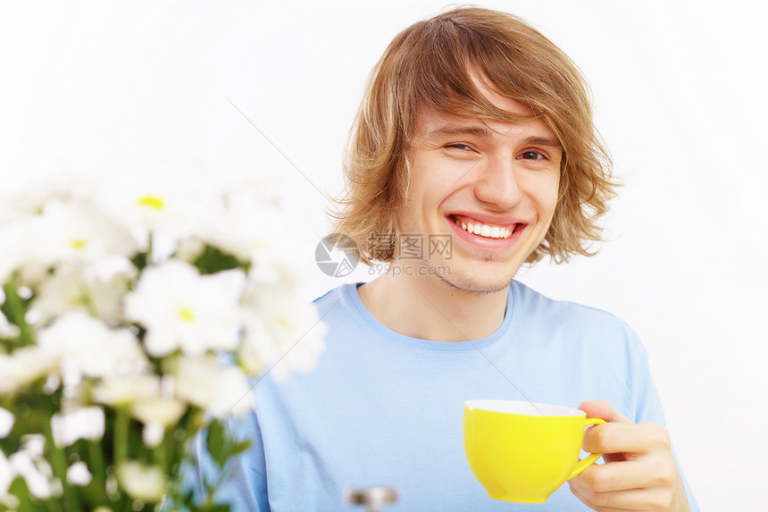 快乐的年轻人喝茶微笑男人闲暇成人乐趣厨房杯子生活男性幸福图片