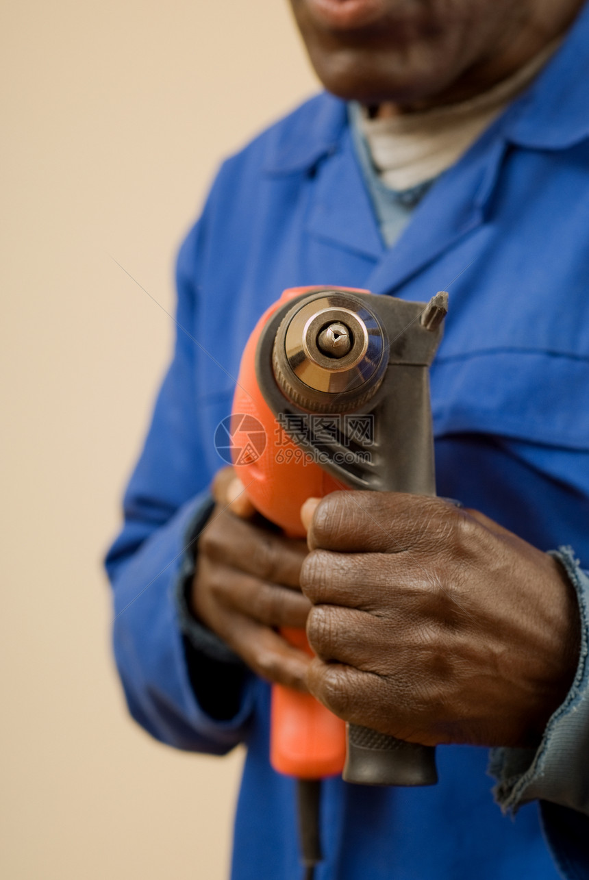 带有电动工具的建筑工人男性修理工安全钻头橙子建造工人工作服劳动电气图片