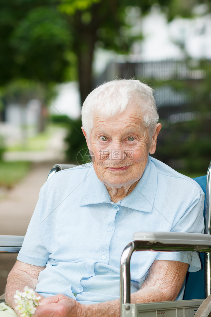 坐在轮椅上快乐的高级女士绿色女性老年祖母微笑长老蓝色树木奶奶退休图片
