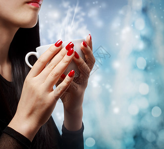 拥有热饮料的妇女指甲抛光头发蒸汽杯子享受女性长发女孩背景美丽的高清图片素材
