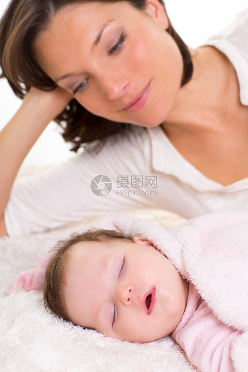 在附近母亲照顾下睡觉的女婴童年女士后代工作室幸福休息享受说谎家庭情感图片