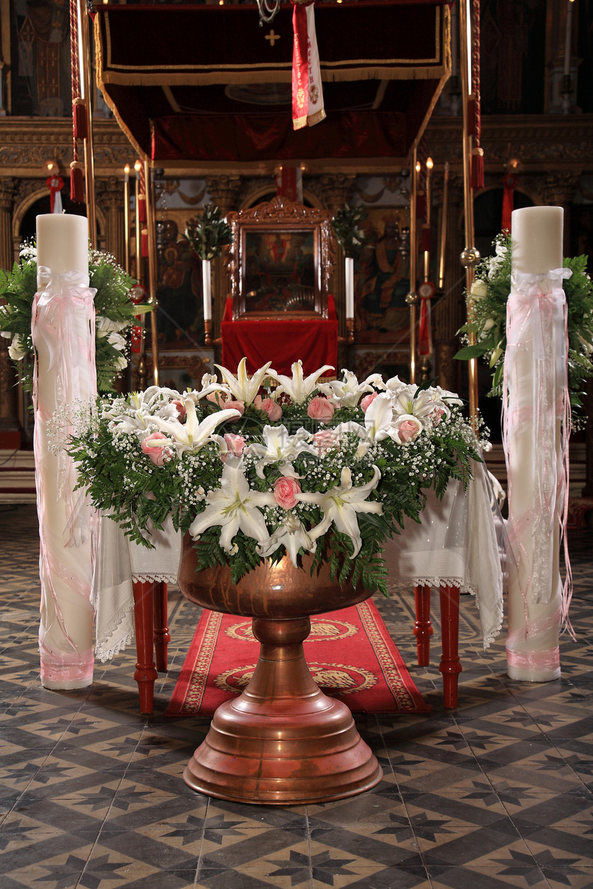 带有花装饰的洗礼碗绿色桌子蜡烛温暖粉红色符号仪式白色花朵面纱图片