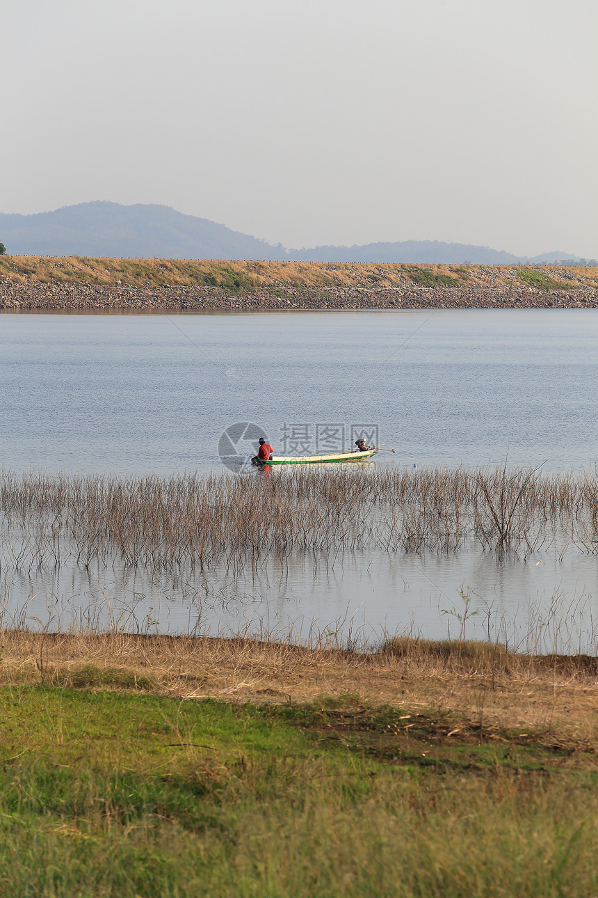 湖边木船上渔民的轮廓风景娱乐假期钓鱼儿子家庭反射活动爱好场景图片