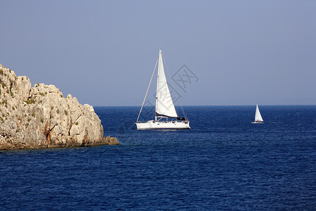 帆船蓝色岩石天空海洋海浪航海游艇白色渔船船长高清图片