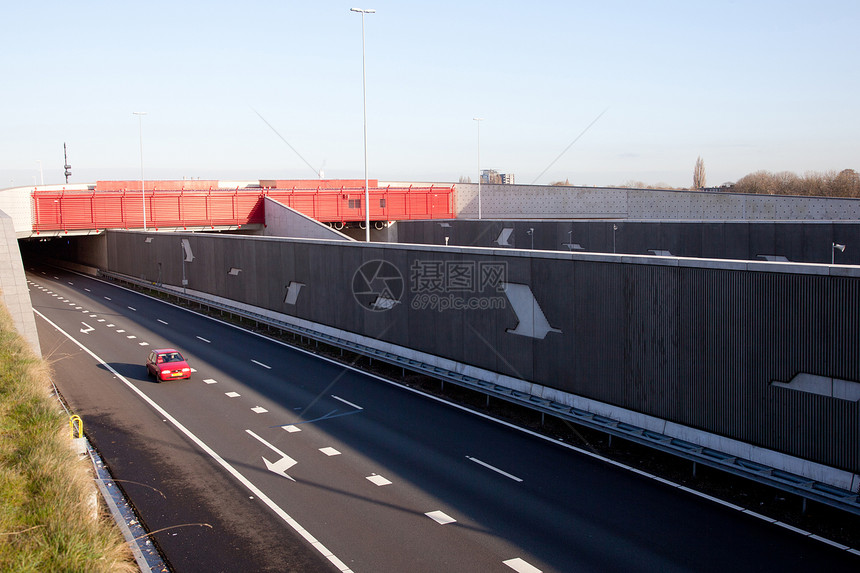 荷兰公路上的红色车红叶隧道 位于荷兰的高速公路上图片