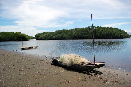 巴布亚新几内亚海滩上带渔网的独木舟海岸热带高清图片