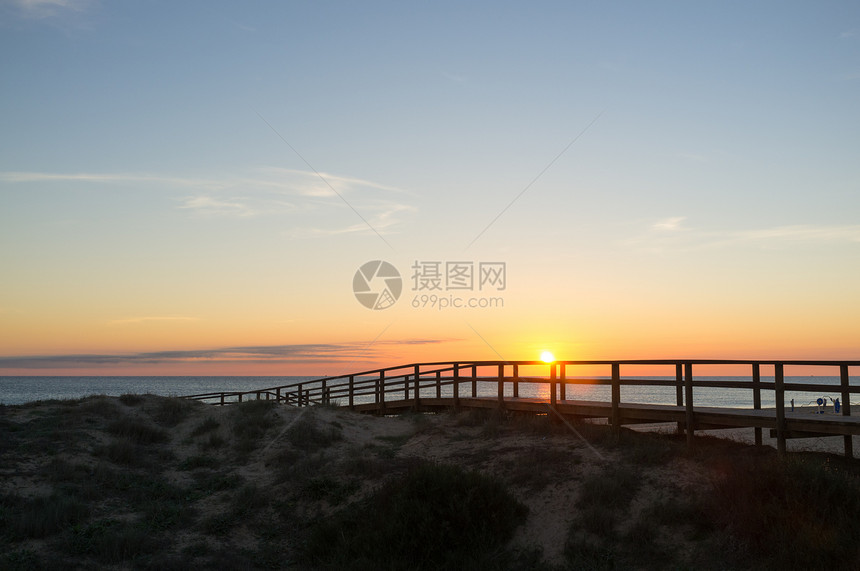 沿海沙丘的日出行人猫步木头海岸支撑海滩水平天桥图片