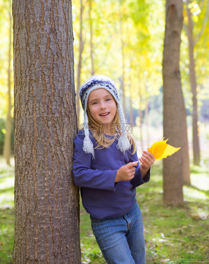 秋天的童女儿童 在阴花林中 黄色落叶手握着帽子季节孩子们树木女孩森林快乐树干树叶金发图片