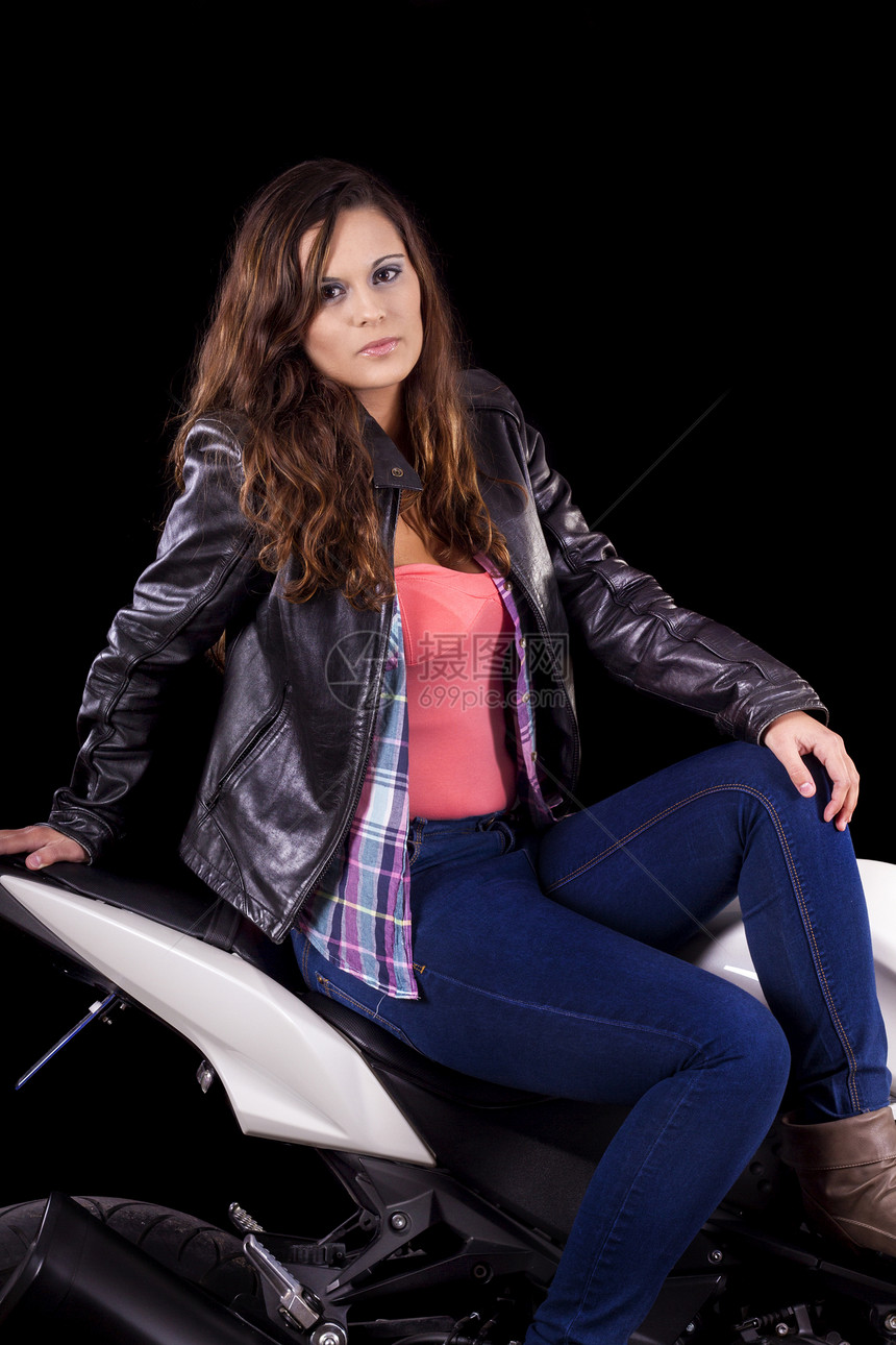 坐在一辆白色摩托车旁边的漂亮女孩衬衫女性车辆皮革夹克牛仔裤司机自行车幸福机器图片