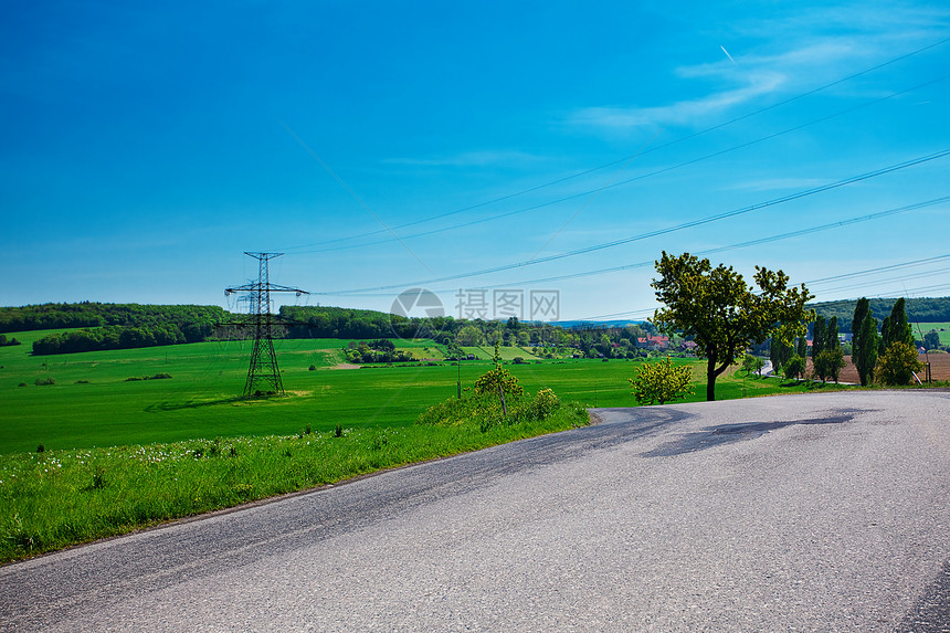 草地和电线对着蓝天全景岩石土地场地太阳车道场景森林美丽牧场图片