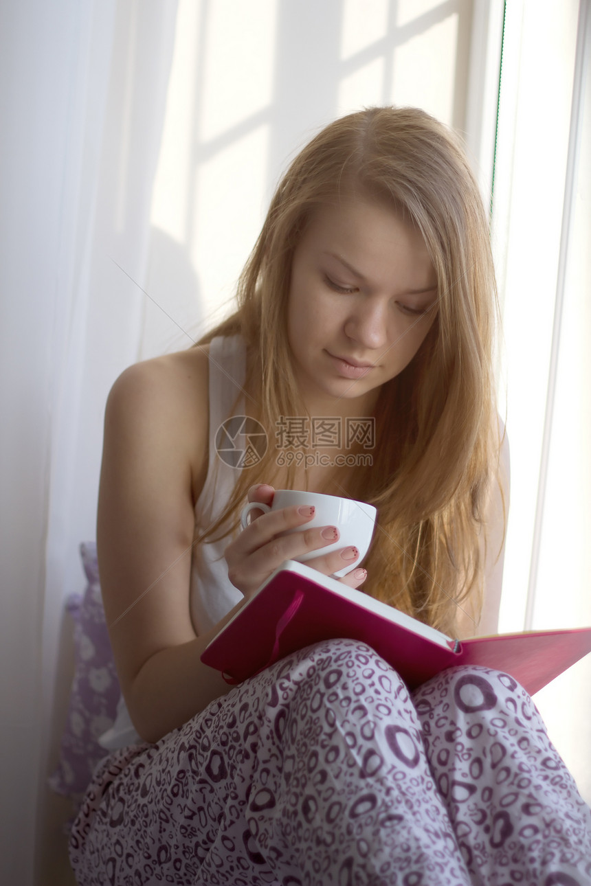 女孩在窗边 拿着一杯咖啡的阅读书建筑杯子窗台长发金发女郎公寓女士幸福日记乐趣图片