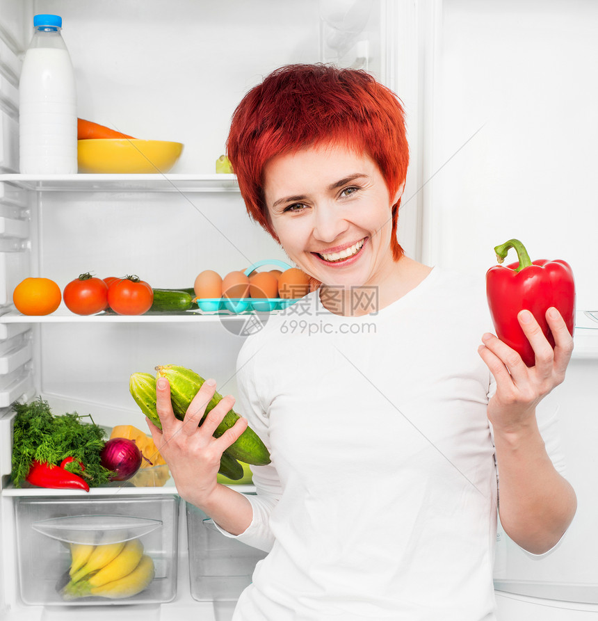 妇女对冰箱的反对水果厨房食物黄瓜成人微笑蔬菜洋葱生活胡椒图片