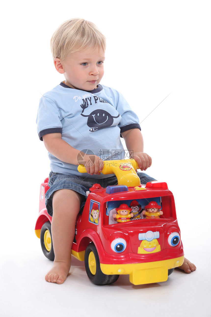 小男孩坐在玩具车上图片