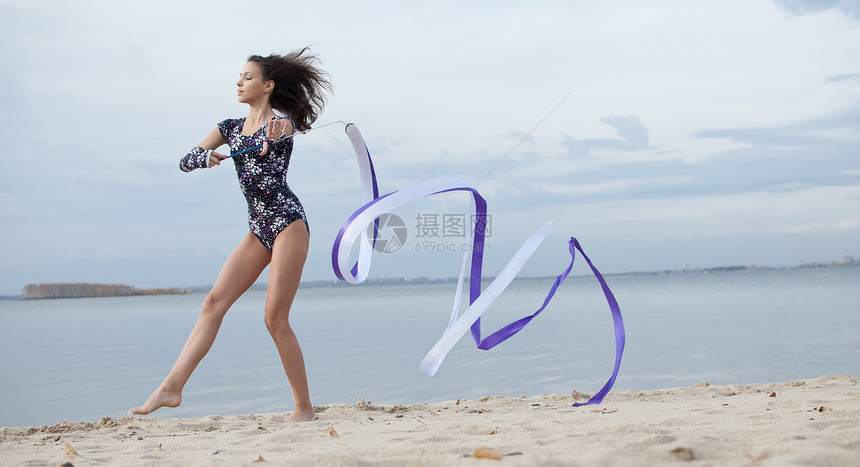 年轻体操女子与丝带跳舞活动乐队运动员女性微笑天空闲暇身体有氧运动青少年图片