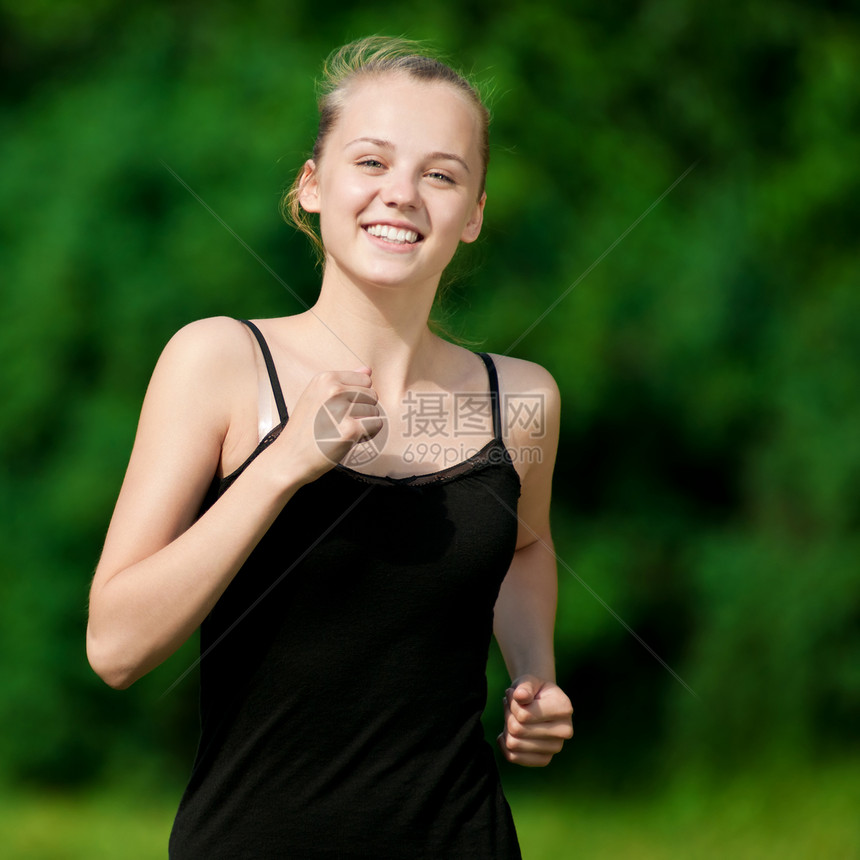 青年女子在绿色公园中奔跑专注女士青少年娱乐慢跑闲暇幸福公园森林头发图片