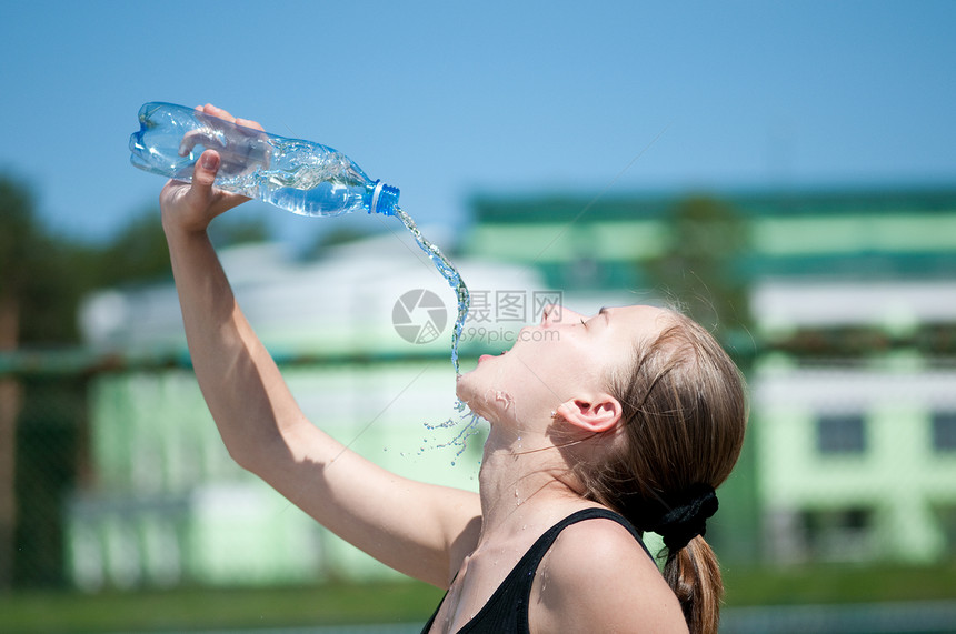 年青妇女锻炼后饮用饮用水运动员天空长发闲暇瓶子女性成人口渴青少年女士图片