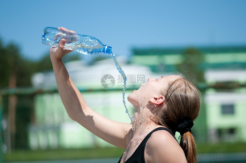 年青妇女锻炼后饮用饮用水长发运动活力太阳天空青少年口渴女孩运动员闲暇图片