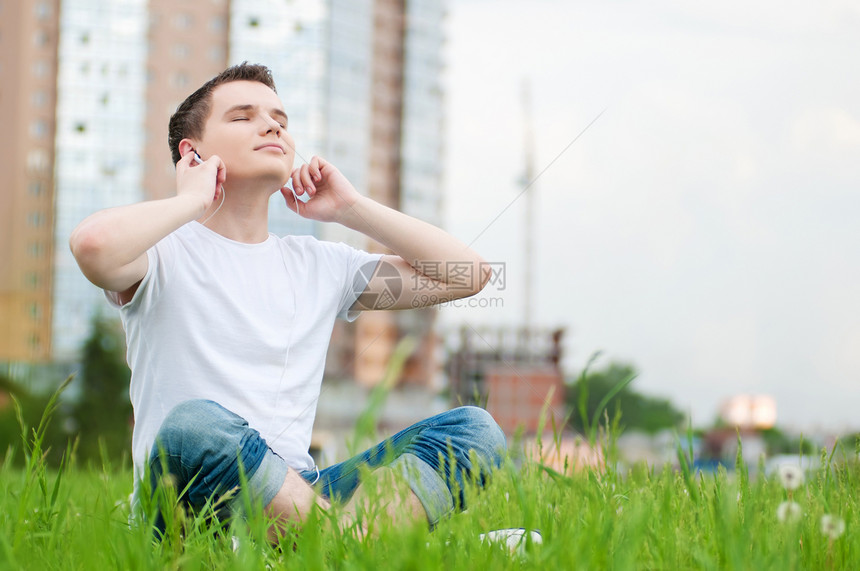 有耳机的有吸引力的年轻人娱乐生活快乐天空自由男性音乐美丽蓝色男人图片