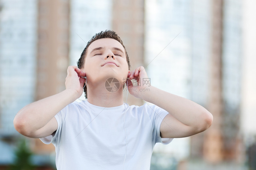 有耳机的有吸引力的年轻人天空青年闲暇街道生活男生男性音乐男人自由图片