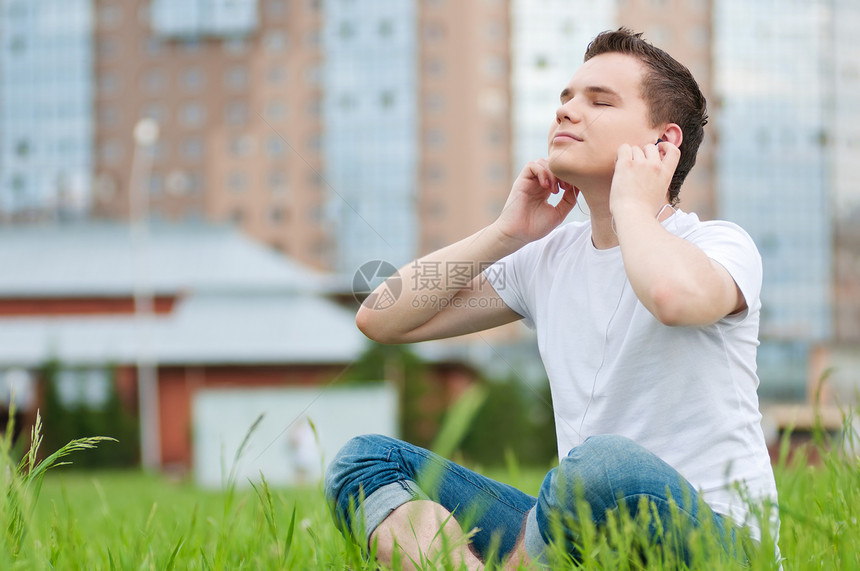 有耳机的有吸引力的年轻人公园街道城市音乐播放器男性娱乐自由男生闲暇假期图片