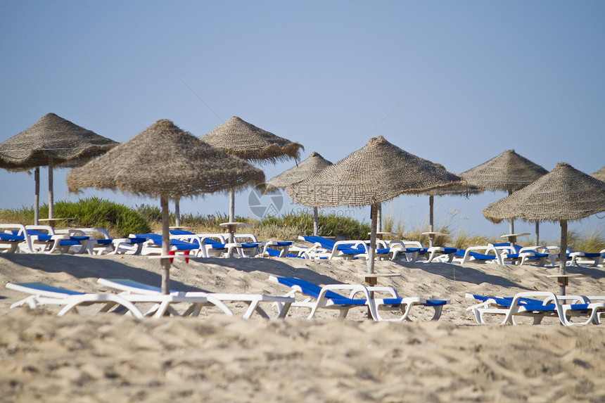 带草伞的沙椅稻草娱乐美丽支撑旅行假期蓝色海岸海滨晴天图片