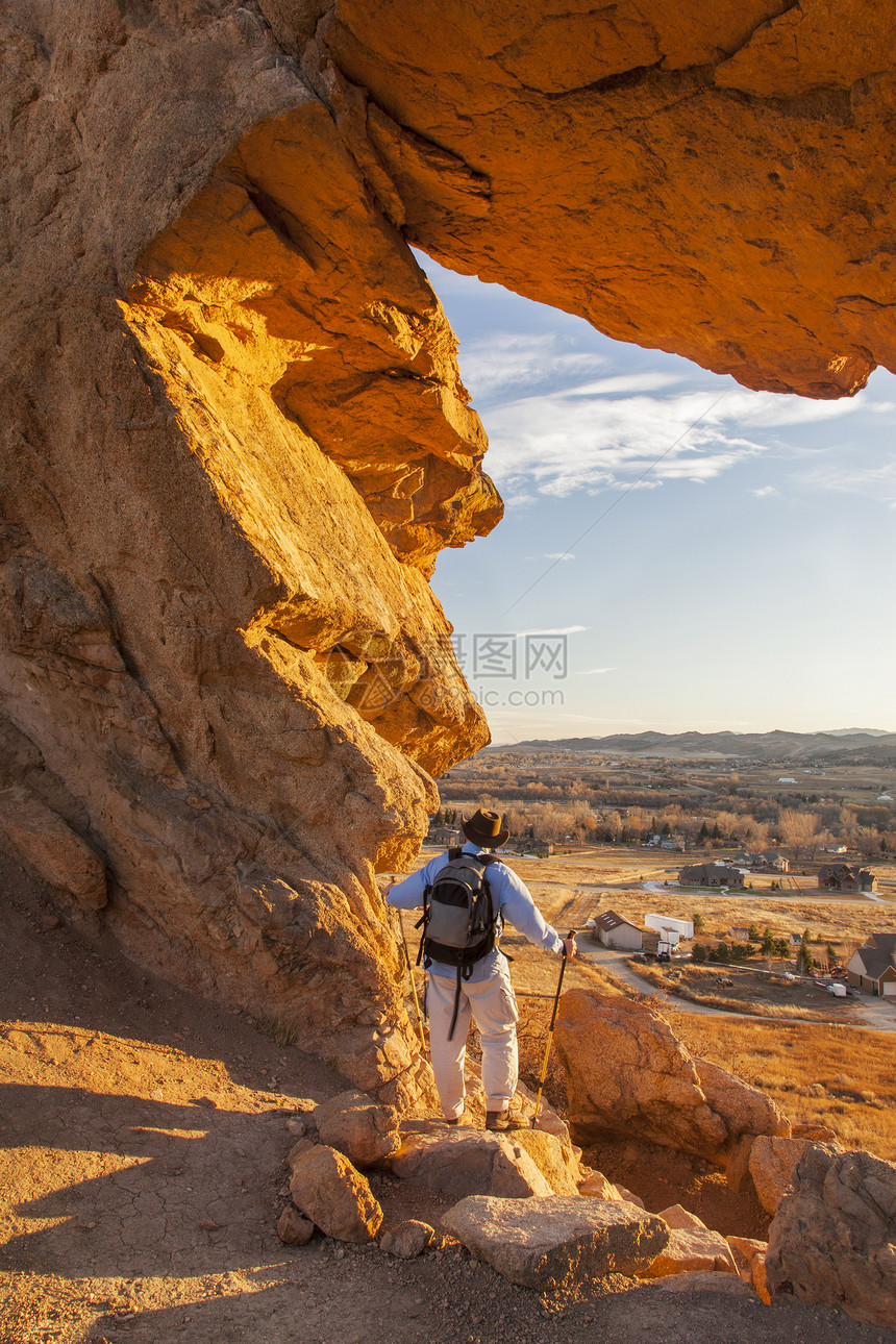 魔鬼后骨的远足者前端红色背包日落登山杖锁孔橙子范围男性地质图片