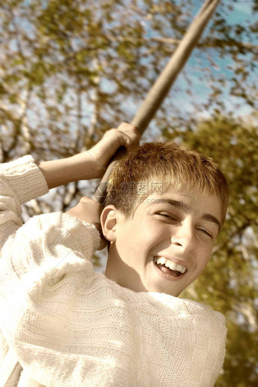 快乐的男孩绳索时间活力衣服青年青春期飞行树木季节公园图片