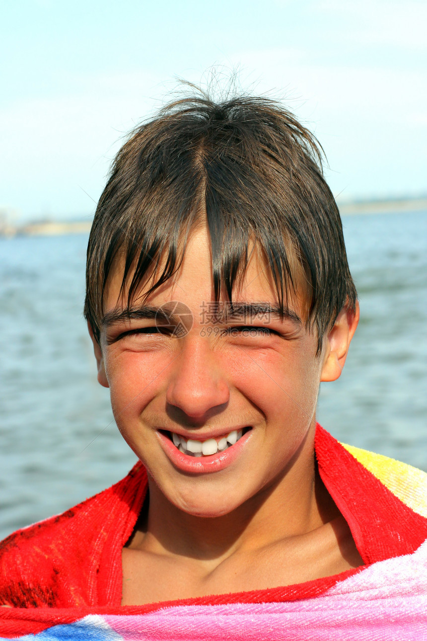 青少年在海滩上幸福孩子乐趣童年假期男性微笑太阳衣服牙齿图片
