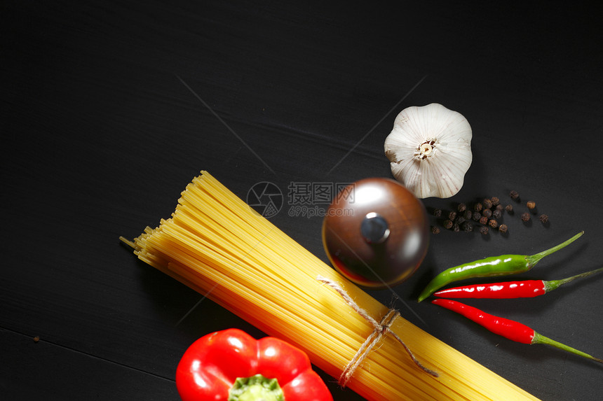 黑桌上的面食成分饮食厨房胡椒香料红辣椒蔬菜烹饪辣椒美食桌子图片